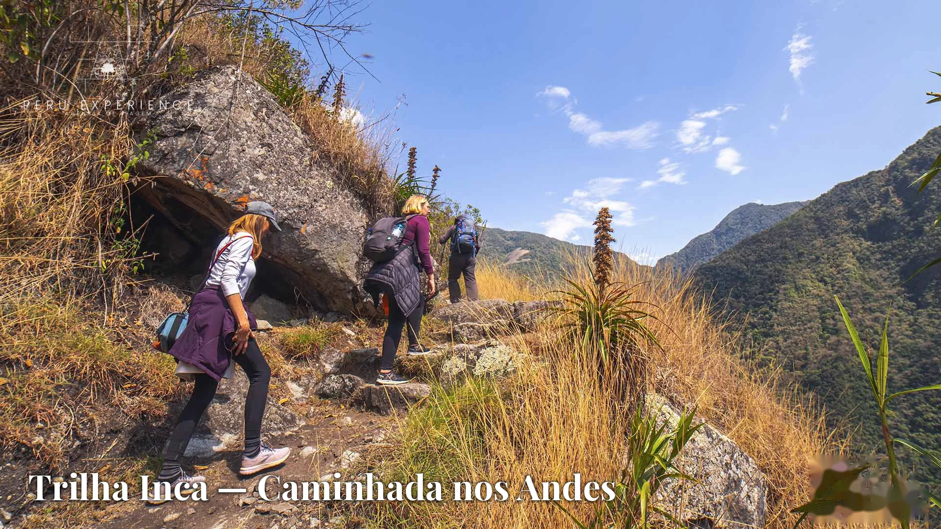 Grupo de trekkers brasileiros subindo trilha de pedras nos Andes peruanos com céu azul — Trilha Inca, Cusco