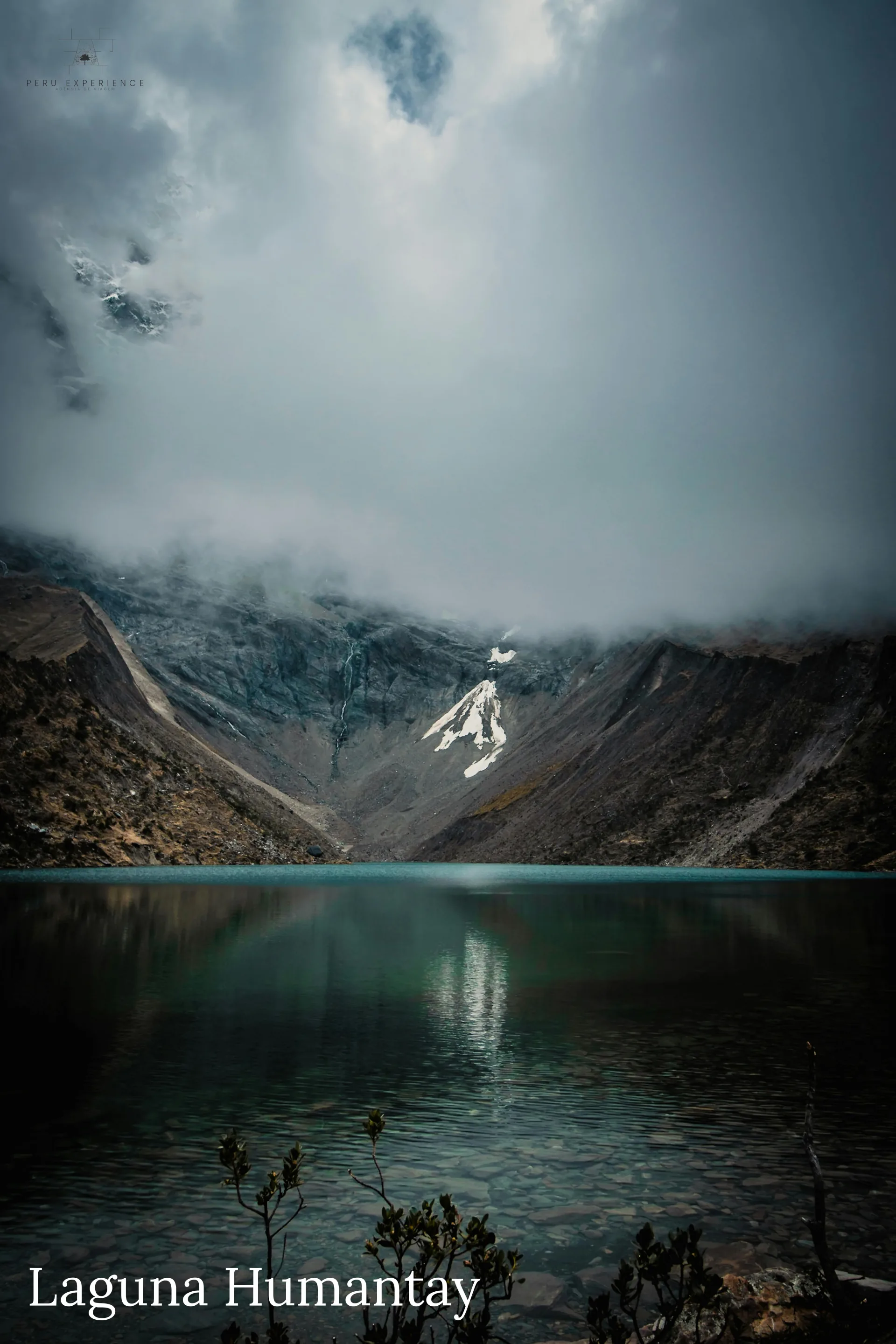 Lagoa de Humantay envolta em neblina mística com o Apu Salkantay (6.271m) parcialmente visível entre as nuvens — atmosfera espiritual sagrada para a tradição andina, Cordilheira Vilcabamba, Cusco, Peru