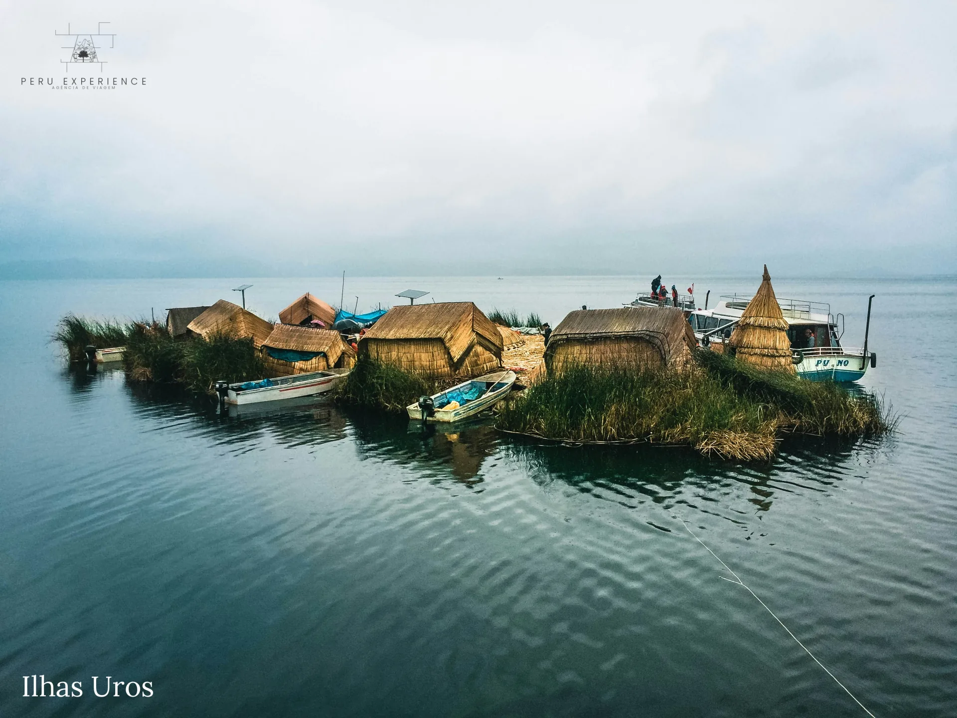Ilha flutuante dos Uros ao amanhecer com neblina sobre as águas espelhadas do Lago Titicaca — casas e barcos de totora, embarcação Puno ancorada, Peru