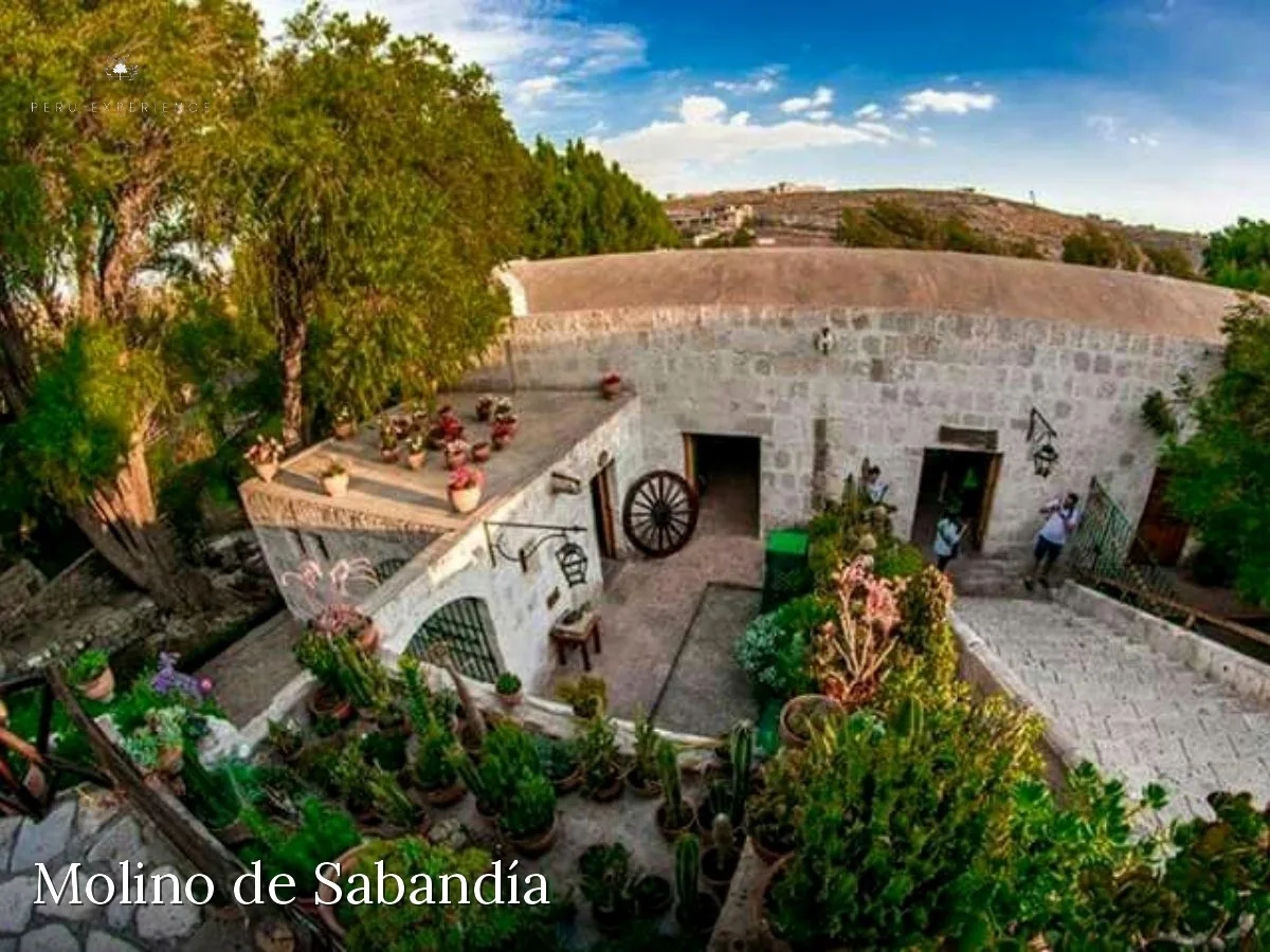Molino de Sabandía em pedra sillar branca cercado por jardins e pela campiña arequipenha — engenho hidráulico colonial do século XVII ainda em funcionamento
