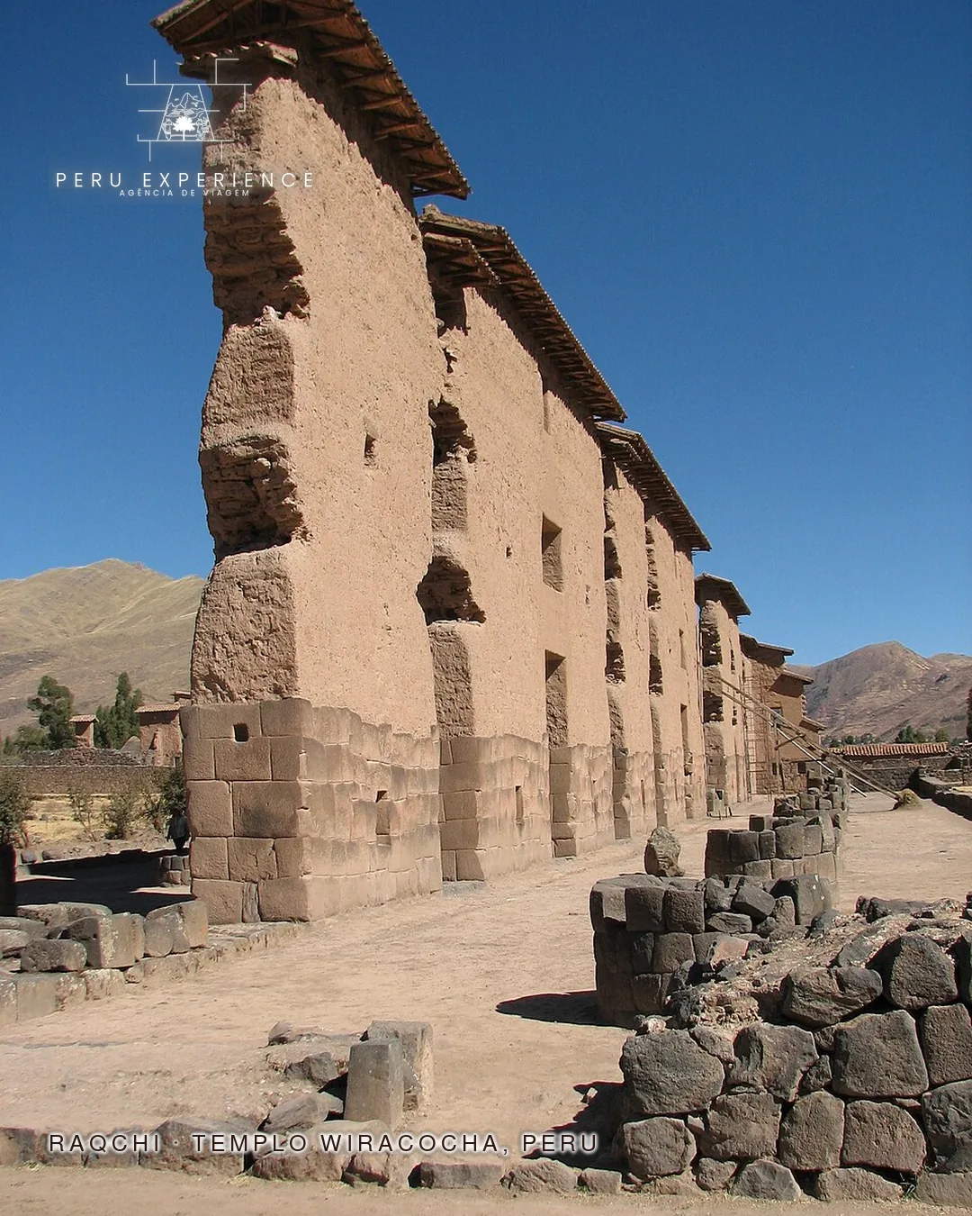 Detalhe das paredes de adobe do Templo de Wiracocha em Raqchi mostrando a altura monumental sobre a base de pedra inca polida — fileira de pilastras alinhadas do maior santuário religioso inca, sítio arqueológico próximo a Cusco