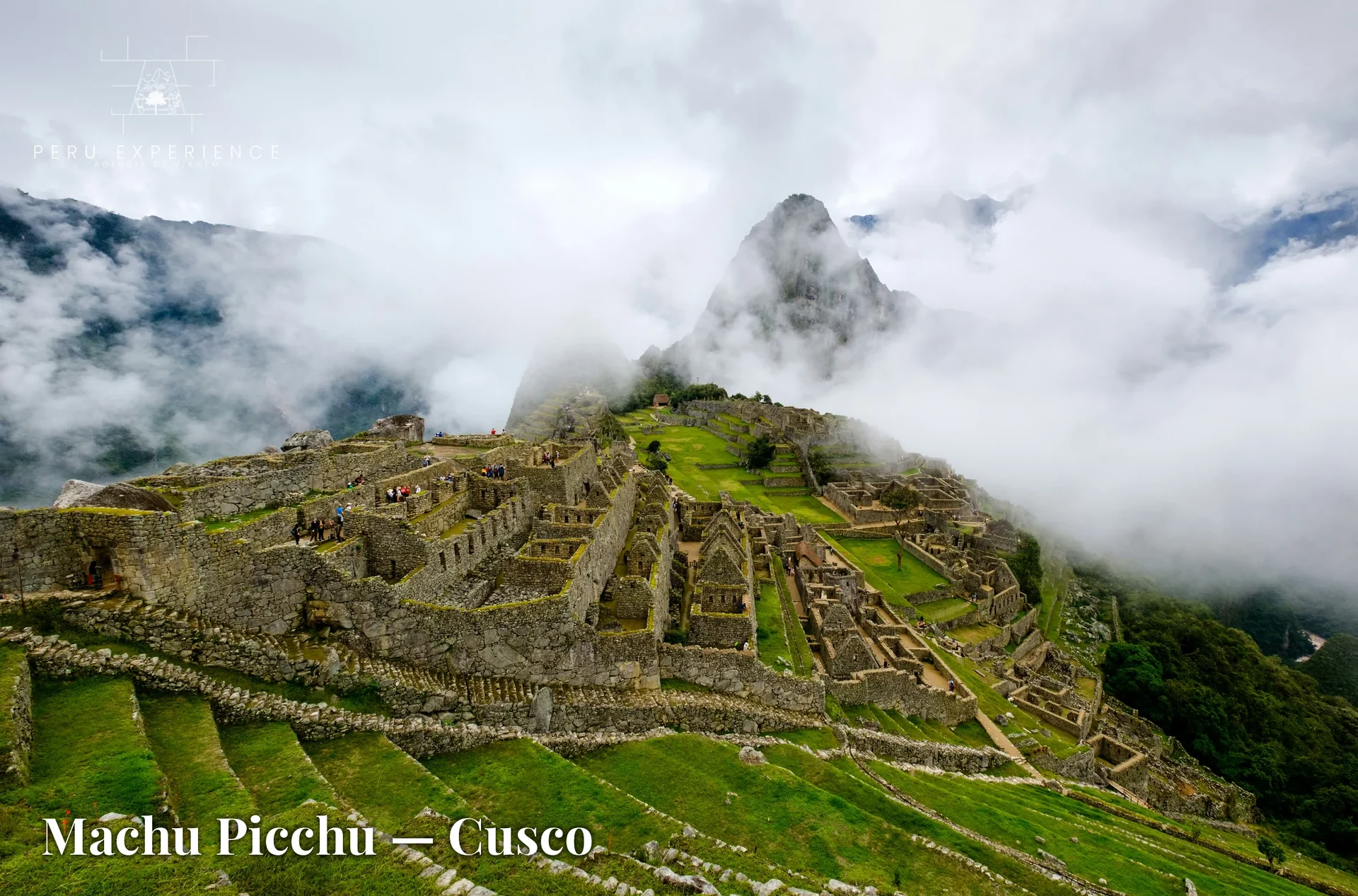 Ruínas de Machu Picchu nas primeiras horas da manhã com nuvens baixas cobrindo o vale