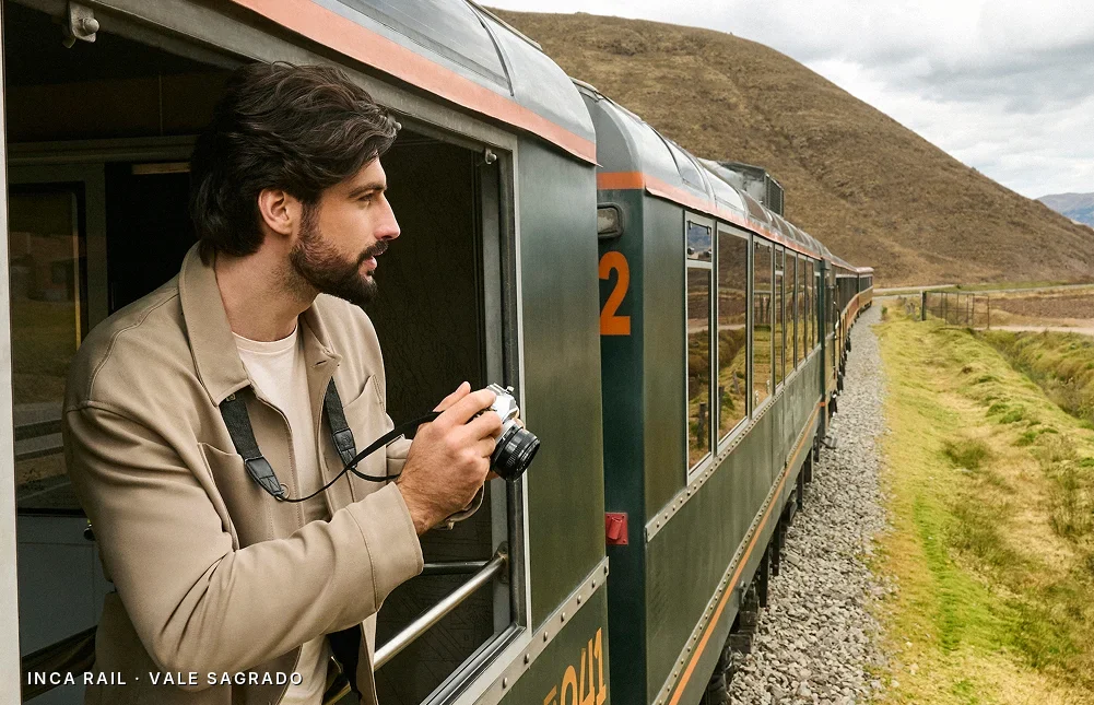Viajante fotografando a paisagem do Vale Sagrado da janela de um trem da Inca Rail