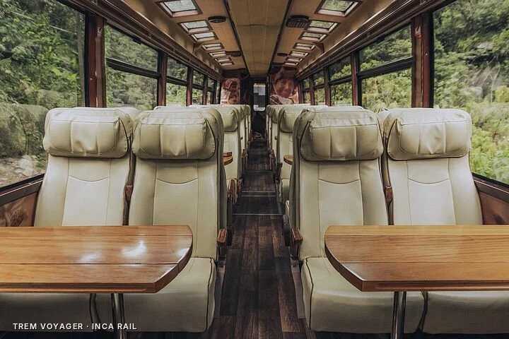 Interior do trem Voyager da Inca Rail com poltronas e mesas