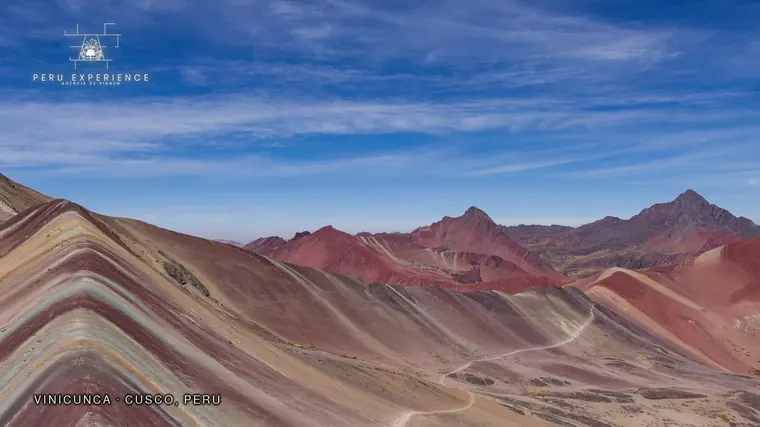 Viagem privativa ao Peru: como montar um roteiro só para o seu grupo Faixas coloridas da Montanha Vinicunca sob céu azul, na região de Cusco